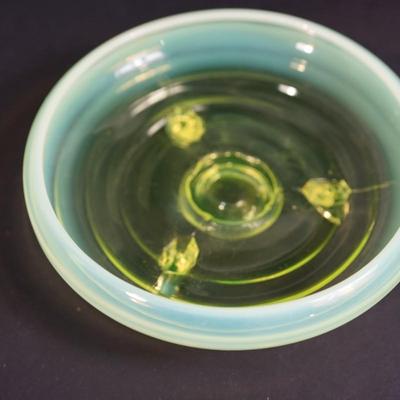 Sale Photo Thumbnail #71: 6" low bowl of 2" in height . Vaseline glass with an opalescent rim,
tiered rib pattern  
three mold blown glass
footed(3) 
good condition. Slight scratches inside but not bad. 
UV light tested fluorescent