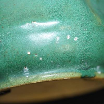 Sale Photo Thumbnail #101: Early 1900's Zanesville pottery vase. 
Matt Green, panelled sides with a flower on every other panel. 
No factory marks found. 
Height: 7 1/4" 
Opening: 4 3/4" 
condition. Good. no cracks or chips noted. There are a tiny specks of where sand from the kiln