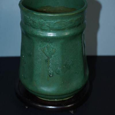 Sale Photo Thumbnail #98: Early 1900's Zanesville pottery vase. 
Matt Green, panelled sides with a flower on every other panel. 
No factory marks found. 
Height: 7 1/4" 
Opening: 4 3/4" 
condition. Good. no cracks or chips noted. There are a tiny specks of where sand from the kiln