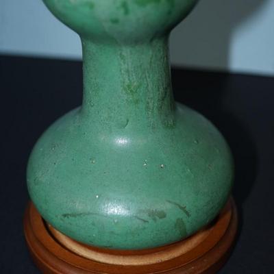 Sale Photo Thumbnail #103: Zanesville Ohio green matt green glazed vase. 
Height just under 6" at 5 3/4"
"corsette waste with bulbous base . 
Marked 60 on the base. 
There are stains in areas of the glaze, see photos. 
slight wear around the rim and or where the glaze did not take.