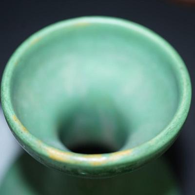 Sale Photo Thumbnail #107: Zanesville Ohio green matt green glazed vase. 
Height just under 6" at 5 3/4"
"corsette waste with bulbous base . 
Marked 60 on the base. 
There are stains in areas of the glaze, see photos. 
slight wear around the rim and or where the glaze did not take.