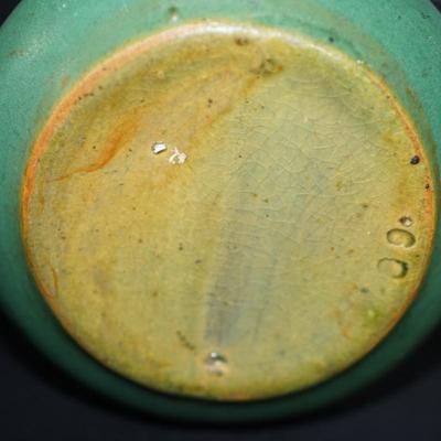 Sale Photo Thumbnail #105: Zanesville Ohio green matt green glazed vase. 
Height just under 6" at 5 3/4"
"corsette waste with bulbous base . 
Marked 60 on the base. 
There are stains in areas of the glaze, see photos. 
slight wear around the rim and or where the glaze did not take.