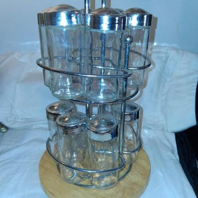 Sale Photo Thumbnail #151: Glass Jars with Metal(?) Lids. Wood & Metal & Wood rotating Holder. Great condition. Appears as if one jar is missing but there isn't.  Came with an empty slot.