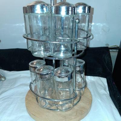 Sale Photo Thumbnail #149: Glass Jars with Metal(?) Lids. Wood & Metal & Wood rotating Holder. Great condition. Appears as if one jar is missing but there isn't.  Came with an empty slot.