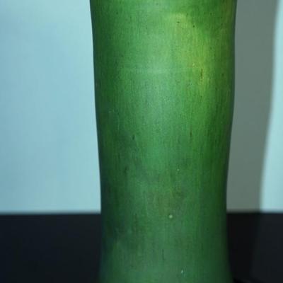 Sale Photo Thumbnail #180: a 12" vintaGE cyclinder form vase. matt green slip glaze with yellow color. 
The base is a yellow clay glazed. 
no markings found. 
Good condition. a few factory flaws along the top edge but these are not chips. 
Very classic looking piece.