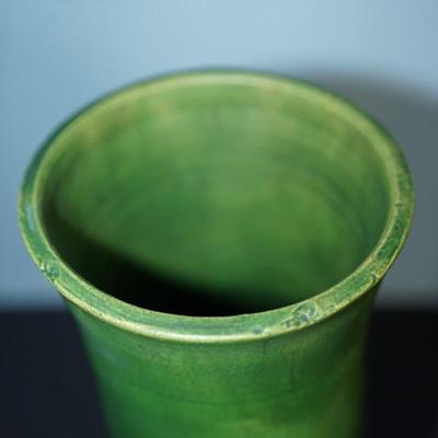 Sale Photo Thumbnail #175: a 12" vintaGE cyclinder form vase. matt green slip glaze with yellow color. 
The base is a yellow clay glazed. 
no markings found. 
Good condition. a few factory flaws along the top edge but these are not chips. 
Very classic looking piece.