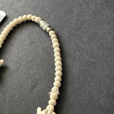 vintage hand-carved elephant necklace, likely made from bone, celluloid, or a similar material.