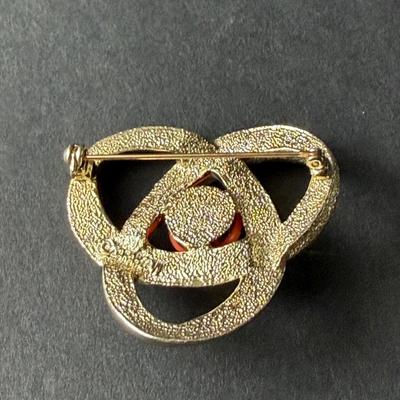 Sarah Coventry "Orbit" brooch in gold-tone metal with a faux coral cabochon center.