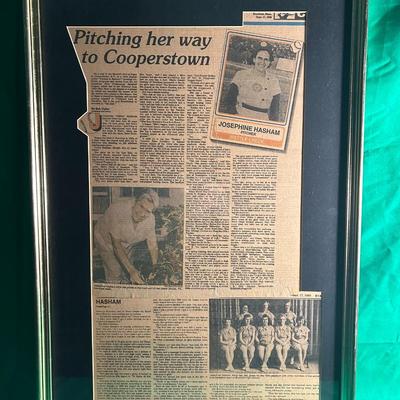 Sale Photo Thumbnail #41: Framed news article featuring baseball pitcher Josephine Hasham displayed under glass with a silver or metallic frame. The clipping appears to discuss achievements related to pitching and a potential connection to Cooperstown. Includes a small photo and s