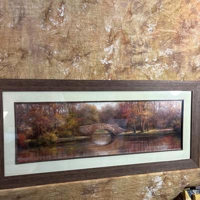 Sale Photo Thumbnail #267: Beautiful fall colors in this pictorial of trees, bridge and water. Print displays a signature. Great frame measuring 44“ x 20“.