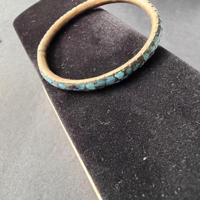 vintage brass bangle bracelet featuring crushed turquoise chip inlay, often associated with a Southwestern or Indian style