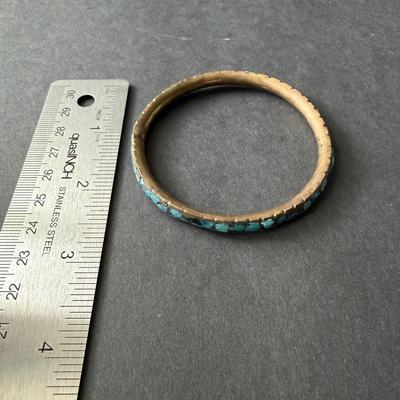 vintage brass bangle bracelet featuring crushed turquoise chip inlay, often associated with a Southwestern or Indian style