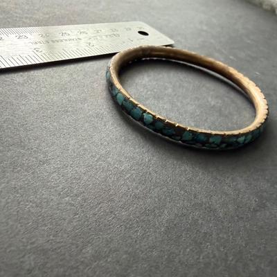 vintage brass bangle bracelet featuring crushed turquoise chip inlay, often associated with a Southwestern or Indian style