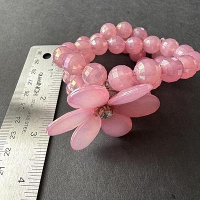 Light pink plastic beaded 3 strand with floral middle piece bracelet