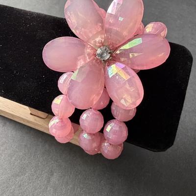 Light pink plastic beaded 3 strand with floral middle piece bracelet