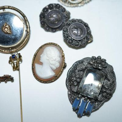 Sale Photo Thumbnail #286: various costume jewelry to include a Victorian keepsake pin, Norway solje pin and other, cameo pin, 
roman coin early pair of clip on earrings.  50's-60's porcelain brooch with hand painted courting scene, 
Clips, pins and a black rhinestone necklace with
