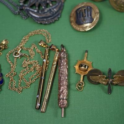 Sale Photo Thumbnail #306: two class rings, onyx and sterling?
white metal and brass watch fobs
eagle pin signed
two avaiator pins -sterling
merchant marine pin - sterling'
brass cuff link of roman coin repro 
rose gold plate golf or card pencil
Alva sun burst pendant 
other...