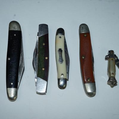 Sale Photo Thumbnail #313: grouping of six pocket knives. two wood and other. Mother of pearl style finish plastic 

Caterpillar advertising ( good condition) hardplastic case decal 
there are stains on the wood  handled knives and the 1" one is not working -lever to fold into the 