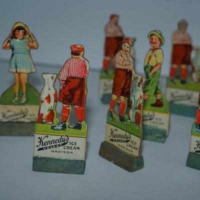 Sale Photo Thumbnail #398: grouping of 11 Kennedy Dairy carboard cut outs of children and advertising of Kennedy Dairy of Madison, WI 
I would guess these are from the 30's . In good condition and good color except for one the face is missing. 
Otherwise these are a perfect project