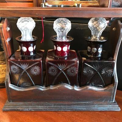 Lot 131-Antique Mahogany Tantalus with Ruby Cut to Clear Bottles