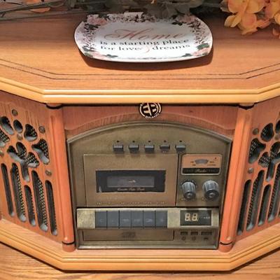 Oak entertainment console loaded with decor and throw-back audio system