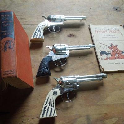 Lot 247: Three 1950's Cowboy Cap Pistols and Adventure Books