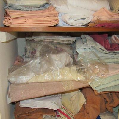 Lot 29 closet full of towels, table cloths and two irons 
