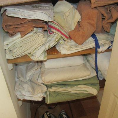 Lot 29 closet full of towels, table cloths and two irons 