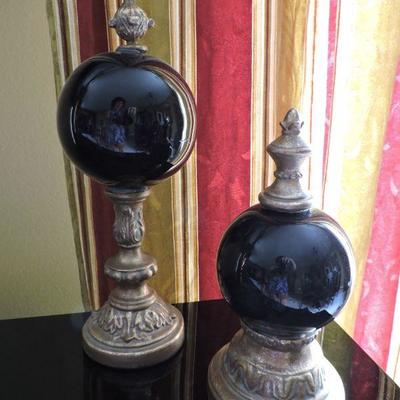 Two Black Orbs With Brass Statues