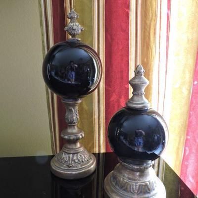 Two Black Orbs With Brass Statues