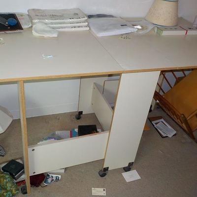 Fold up craft table with fold down sizes and wheels.
