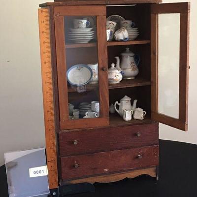 Charming miniature cabinet complete with miniature dishes.