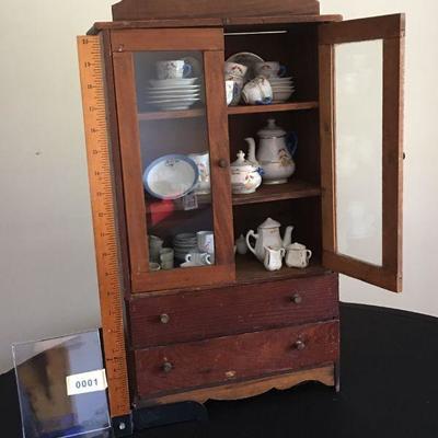 Charming miniature cabinet complete with miniature dishes.