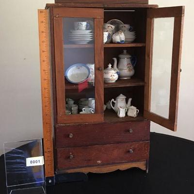 Charming miniature cabinet complete with miniature dishes.