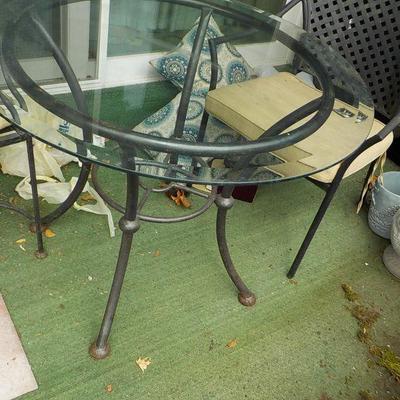 Solid  Wrought iron garden outside table and chairs/ glass top.