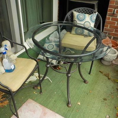 Solid  Wrought iron garden outside table and chairs/ glass top.