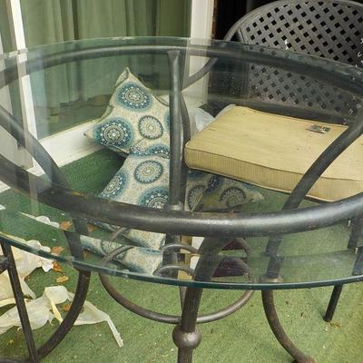Solid  Wrought iron garden outside table and chairs/ glass top.