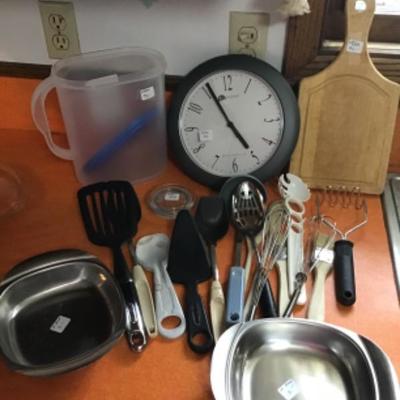 #k19. Two stainless steel dishes, clock, cutting board and miscellaneous utensils