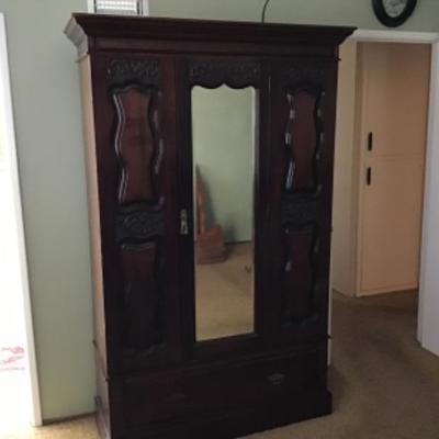 B3-101 Antique armoire nicely carved with beveled mirror