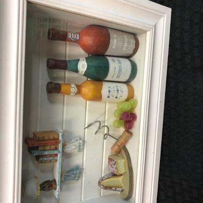 Miniature Kitchen Scene in 3D white frame with small bottles, miniature bread, wine grapes, corkscrew and shelf