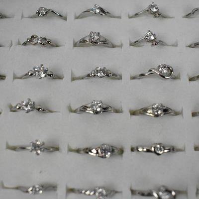 Qty 100 Costume Jewelry Rings, ranging from sizes 4.5-9. Includes Display - New