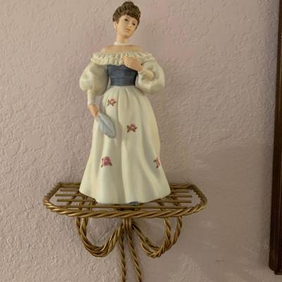 Figurine standing on brass designed shelf