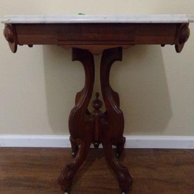 LOT 52   MARBLE TOP ANTIQUE SIDE TABLE ON CASTERS