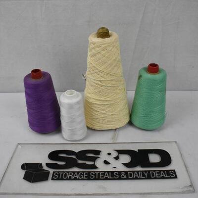 4 large spools of thread: White, Cream, purple, and green