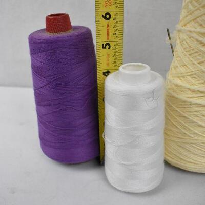 4 large spools of thread: White, Cream, purple, and green