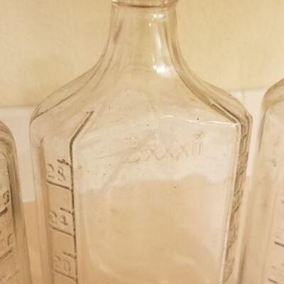 Lot #128: (3) Vintage Large Measuring Impression Glass Bottles