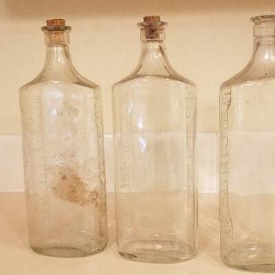 Lot #128: (3) Vintage Large Measuring Impression Glass Bottles