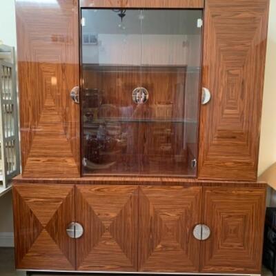 Lot 49. Amazing Giorgio Collection lighted breakfront, whisky colored with geometric design, glass doors and chrome fixtures.  Total...