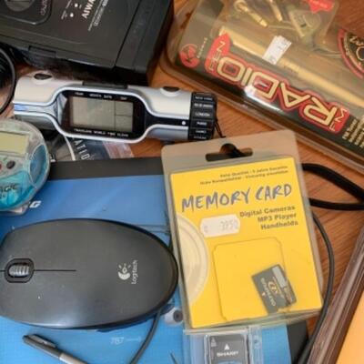Lot 7U. Electronic FM radio in a pen, etc--travel clock, heart monitor, SD memory card, ear phones, wireless router, Apple world travel...