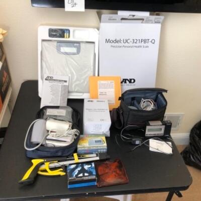 Lot 38U. Travel and Health accessoriesâ€”mugs and heater, 2 blood pressure monitors (new), travel clocks, scale, mirror foldable grabber,...